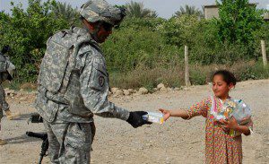 Army Command Sgt. Maj. Thomas Jones Jr. hands a meal to a girl in Samarra, Iraq, March 31, 2009. U.S. Army photo by Ian M. Terry