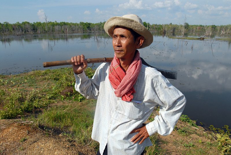 Sre Treng, Cambodia. Tum Them helps clear a dam that irrigates his community's rice fields.