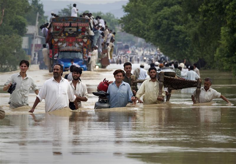 Residents carry their belongings through a flooded road in Risalpur, located in Nowshera District, in Pakistan's Northwest Frontier Province July 30, 2010. About 150 people were killed by flashfloods and bad weather in Pakistan in one week, with the country's northwest and Baluchistan provinces bearing the brunt of the storms. Photo: REUTERS/St-Felix Evens, courtesy of Reuters Alertnet.org