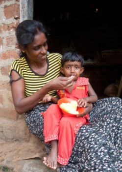 Chandrani feeds her daughter Yasendri. Photo: Tom Greenwood/OxfamAUS