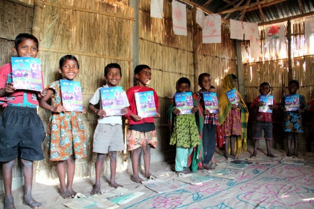 Mominpur Preschool students proudly hold their workbooks. Photo: Tania Cass