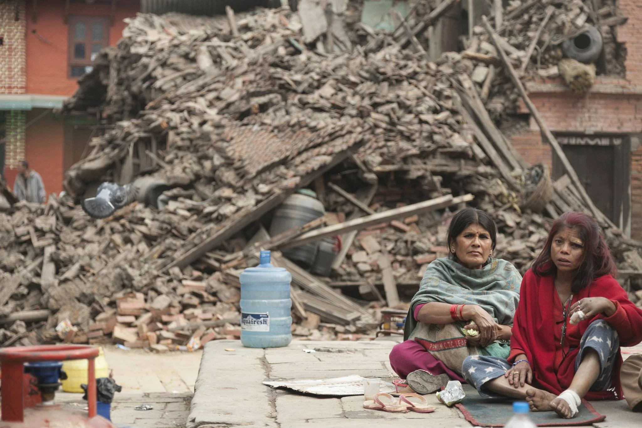 Two locals find safe ground in front of a destroyed structure in Bhaktapur region of Kathmandu, Nepal. Photo credit: EPA/Hemanta Shrestha