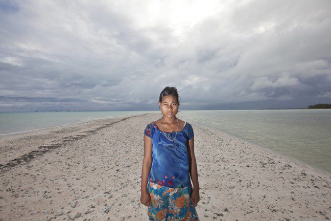 A woman stands on a deserted beach