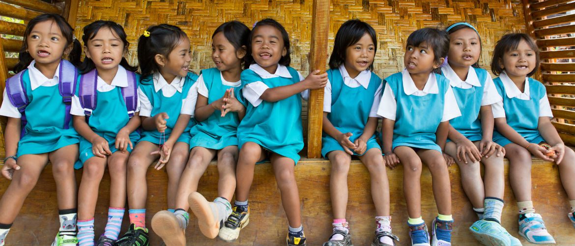School girls sing a song to welcome visitors to the 'reading corner' set up by the village preparedness and response team in Sembalun Lawang, Indonesia.