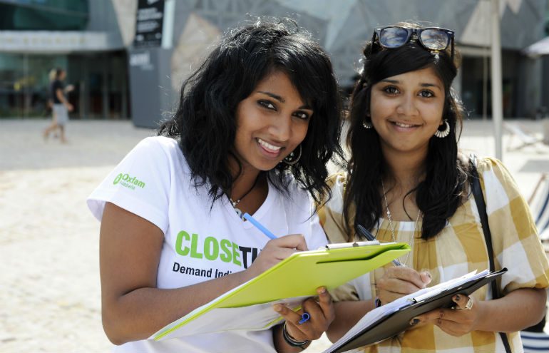 Two young women sign the Clsoe the Gap pledge