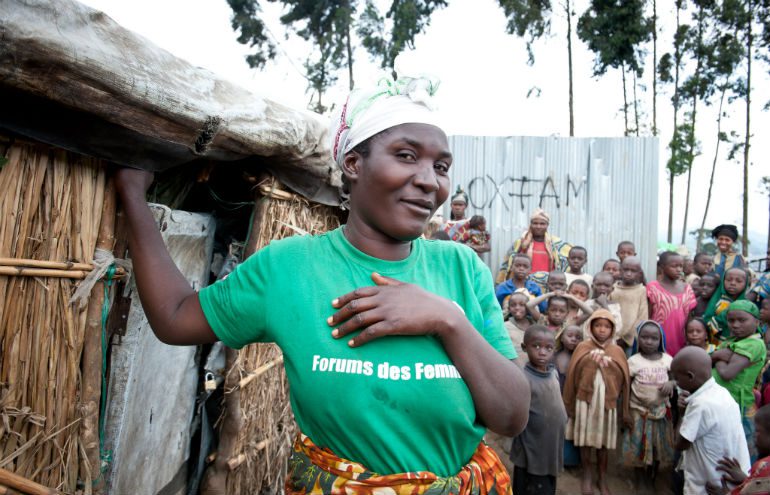 Louise stands in front of children in her community.