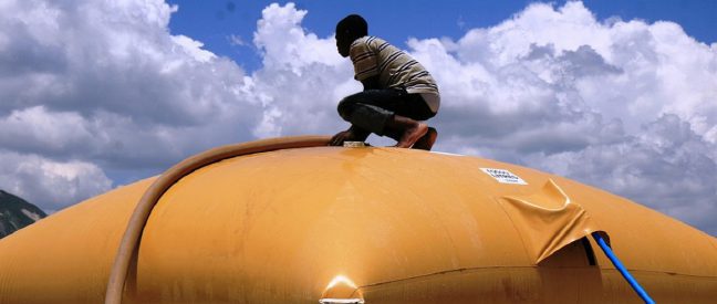 <p>Oxfam provided people with access to clean water following the earthquake in Haiti in 2010 by setting up water points and filling up Oxfam bladders like this one. Photo: Jane Beesley/Oxfam</p>