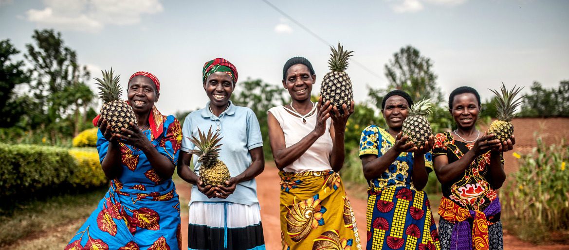 women holding pineapples in Rwanda