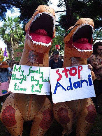 Dinosaurs at the #ClimateStrike with a sign that reads "My Family thought they had time too"