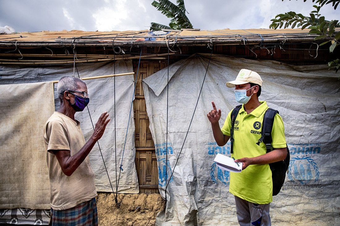 Oxfam volunteer Zahid Hossain (20) is talking to Abdul Malek* (80) about precaution elderly has to take during Covid19 outbreak in the camp. Cox's Bazar, Rohingya refugee camp. Bangladesh