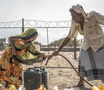 Filling jerry cans with water from the desalination plant in Yemen. Photo: Pablo Tosco