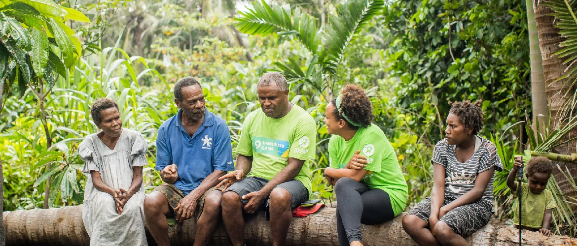 Oxfam staff Maurice and Sandra talk with beneficiaries Johnson Talam and Mere Johnson, joined by Rosie and son. Photo: Arlene Bax