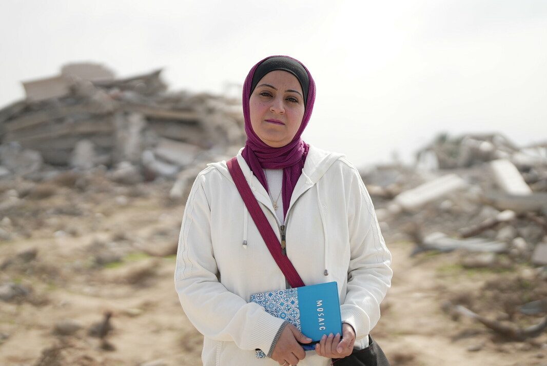 Gaza, Palestinian Territory, Occupied: Fidaa Shurrab, Director of Projects at Atfaluna for Deaf Society in Rafah stands in front of a destroyed building in Gaza strip while going to work. Photo: Alef Multimedia/Oxfam Gaza, Palestinian Territory, Occupied: Fidaa Shurrab, Director of Projects at Atfaluna for Deaf Society in Rafah stands in front of a destroyed building in Gaza strip while going to work. Photo: Alef Multimedia/Oxfam
