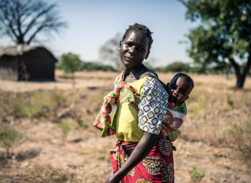 Malawi: Elube (32) stands with her baby in her small plot of farm land. Photo: Aurelie Marrier d'Unienville/Oxfam AUS Malawi: Elube (32) stands with her baby in her small plot of farm land. Photo: Aurelie Marrier d'Unienville/Oxfam AUS