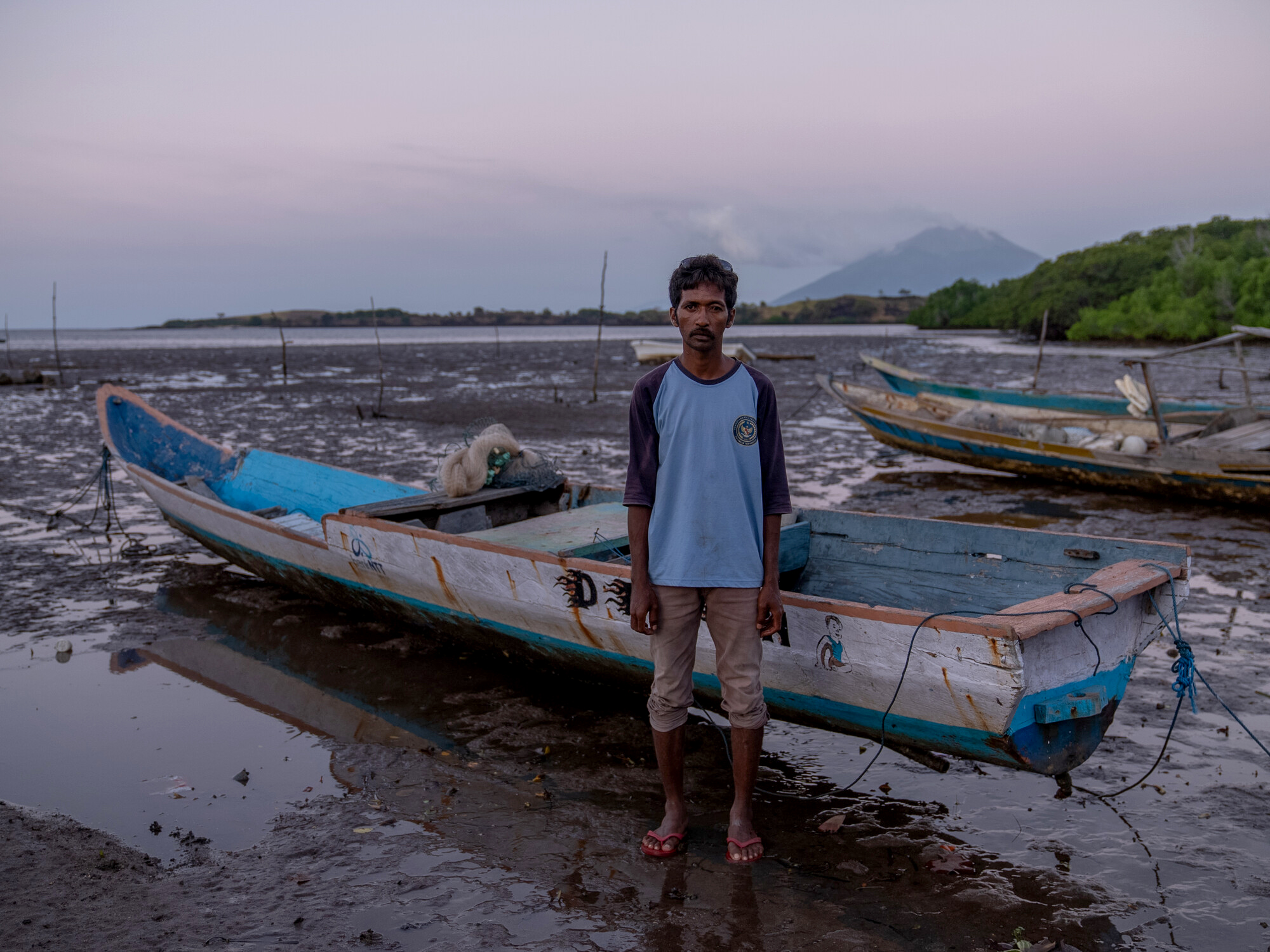 Mekko, Indonesia: Said (33) stands in front of his fishing boat. He now struggles to catch enough fish for his family's daily needs, due to climate change and the fish moving further and further out to sea. Oxfam acknowledges the support of the Australian Government through the Australian NGO Cooperation Program (ANCP). Photo: Vikram Sombu/Oxfam Mekko, Indonesia: Said (33) stands in front of his fishing boat. He now struggles to catch enough fish for his family's daily needs, due to climate change and the fish moving further and further out to sea. Oxfam acknowledges the support of the Australian Government through the Australian NGO Cooperation Program (ANCP). Photo: Vikram Sombu/Oxfam