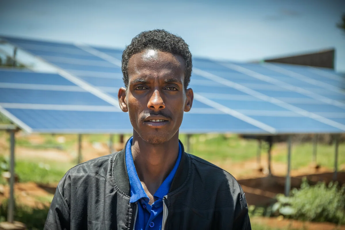 Ethiopia: Mohammud, 27, water bureau head in Ararso says, standing next to the 56-panel solar array that Oxfam installed and now powers the system. Photo: Petterik Wiggers / Oxfam Ethiopia: Mohammud, 27, water bureau head in Ararso says, standing next to the 56-panel solar array that Oxfam installed and now powers the system. Photo: Petterik Wiggers / Oxfam