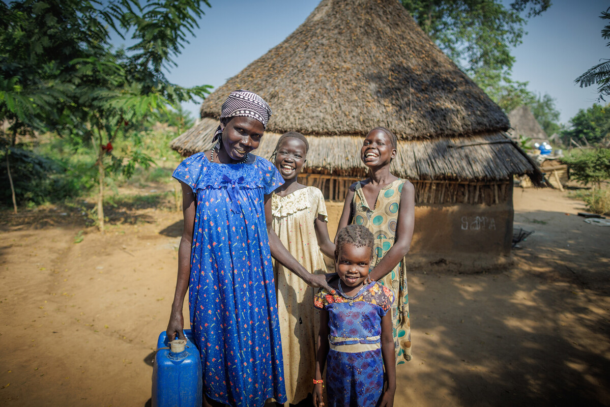 Ethiopia: Refugees are delighted to have received potable water within walking distance from their homes. The project is part of the WASH implementations by Oxfam. The refugee in blue dress is Nyhtuk Hukuch, posing together with her three children. Photo: Petterik Wiggers/Oxfam